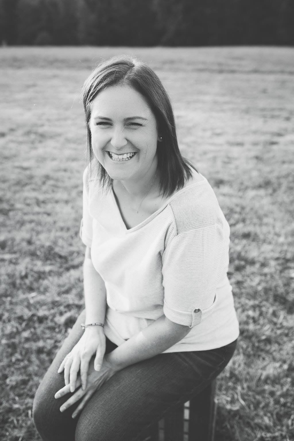 Christine laughing outdoors in a black-and-white portrait
